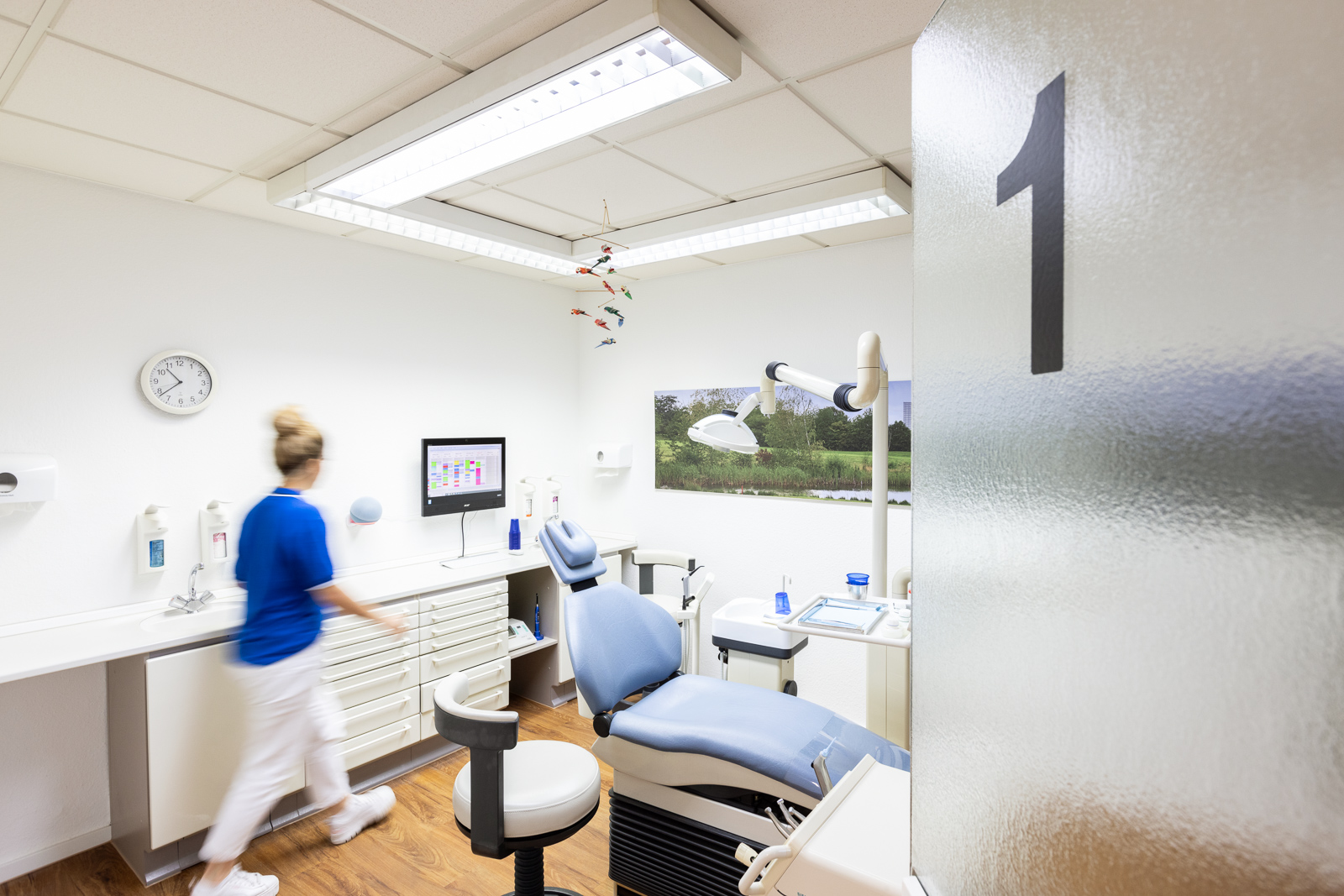 Foto eines Zahnarztbehandlungsraumes mit der Nummer 1, mit Blick durch die Tür