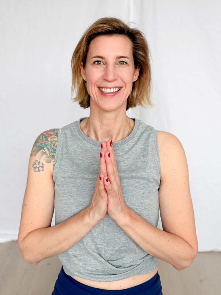 Maxi hält ihre Hände vorm Herzen und lacht in die Kamera.